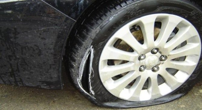 Работник сряза гумите и заля с масло колата на шефа си