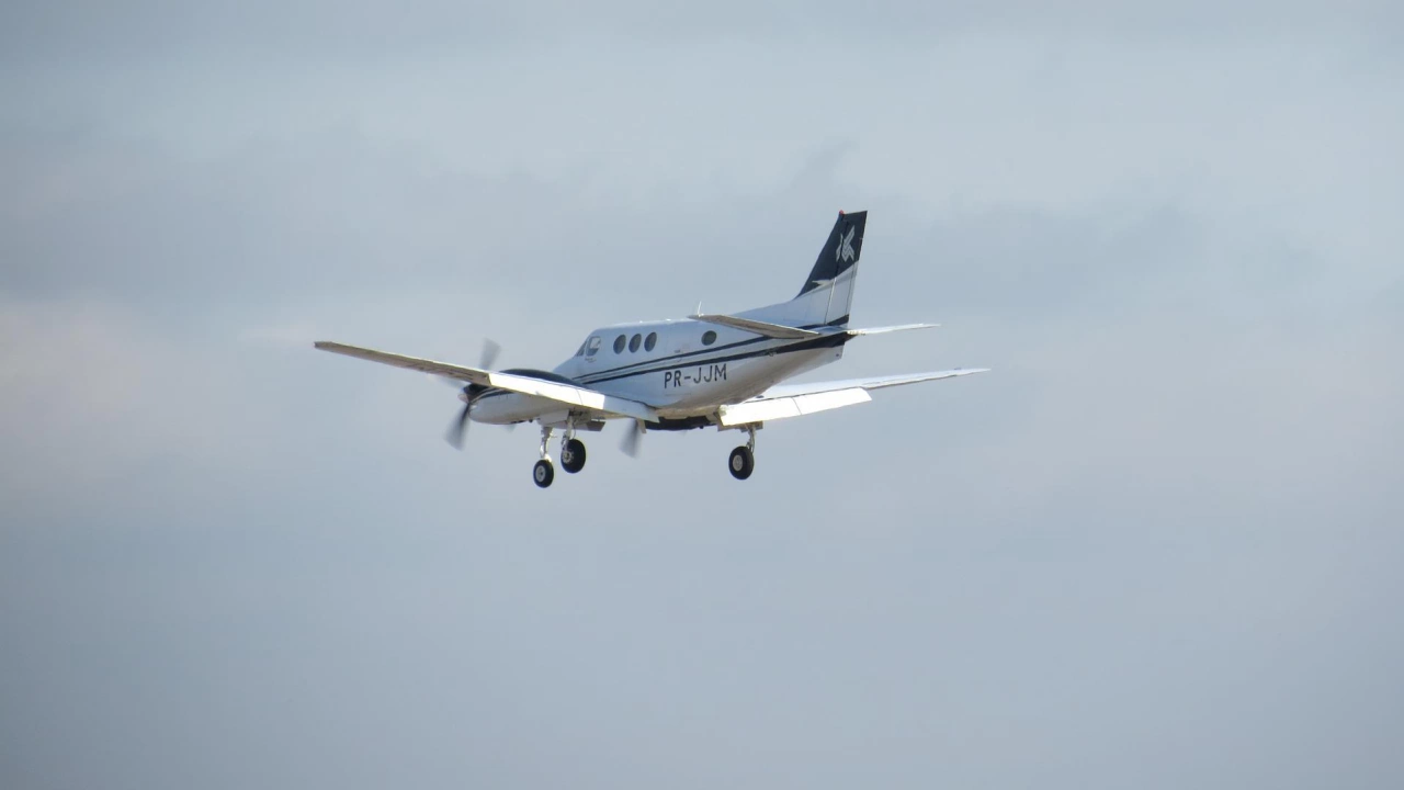Пилот на малък двумоторен самолет прелитащ на град в щата