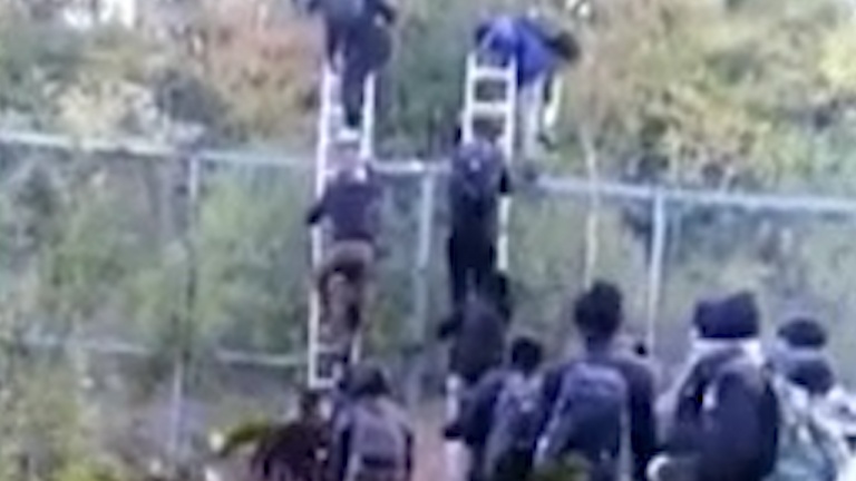 Шок: Мигранти прескачат със стълба оградата на границата